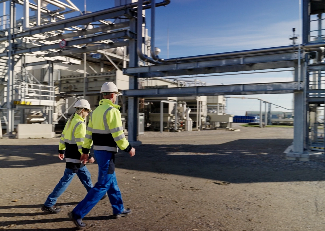 A woman and a man (two OMV employees) on a factory premises (photo)