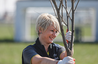 OMV employee holding small tree (photo)